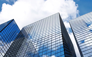 Looking up at buildings against cloud filled sky, Traditional Hosting | DXC Technology Insights